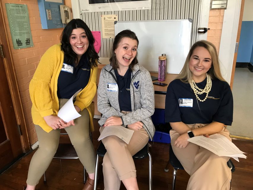 Hannah Belt, Emma Blair, and Jordyn Johnson prepare to discuss different majors with middle school students in Morgantown.